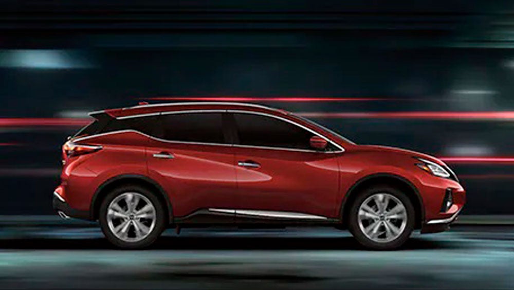 2023 Nissan Murano shown in profile driving down a street at night illustrating performance. | Carlock Nissan Of Tupelo in Tupelo MS